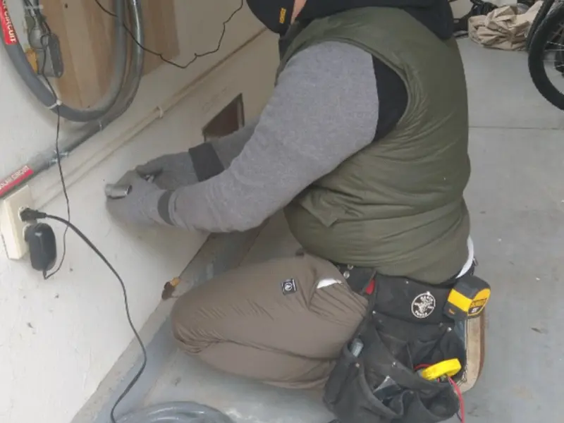 Electrician performing outlet wiring in a Bayville garage